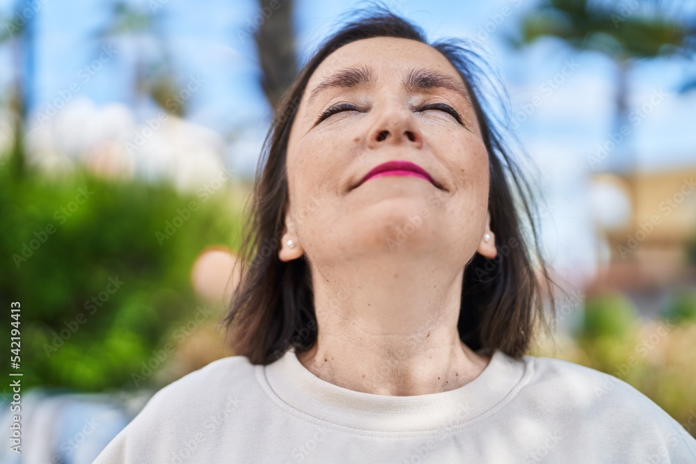 Middle age woman smiling confident breathing at park