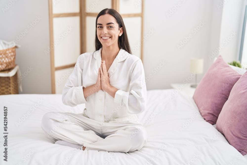 Young hispanic woman doing yoga exercise sitting on bed at bedroom Young hispanic woman doing yoga exercise sitting on bed at bedroom
