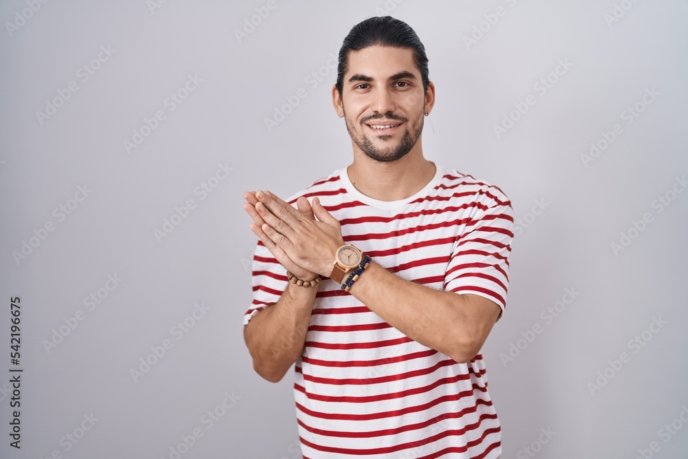 Hispanic man with long hair standing over isolated background clapping and applauding happy and joyful, smiling proud hands together Hispanic man with long hair standing over isolated background clapping and applauding happy and joyful, smiling proud hands together
