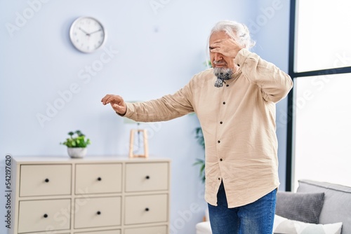 фотографія Middle age grey-haired man suffering dizzy standing at home
