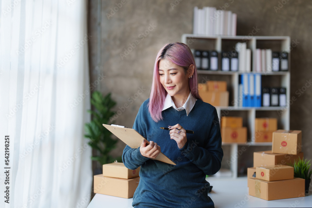 Startup small business entrepreneur of freelance Asian woman using a laptop with box Cheerful success online marketing packaging box and delivery SME idea concept