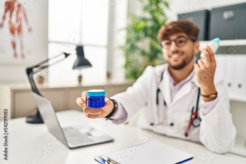 Young arab man wearing doctor uniform choosing respiratory treatment at clinic