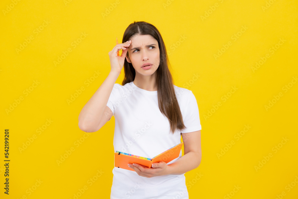 Young student girl in casual clothes, isolated on yellow background studio portrait. Hold notebooks. Cheerful young attractive student woman. Young student girl in casual clothes, isolated on yellow background studio portrait. Hold notebooks. Cheerful young attractive student woman.