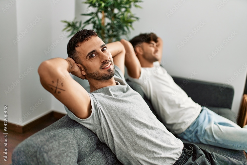 Two hispanic men couple smiling confident relaxed with hands on head at home Two hispanic men couple smiling confident relaxed with hands on head at home