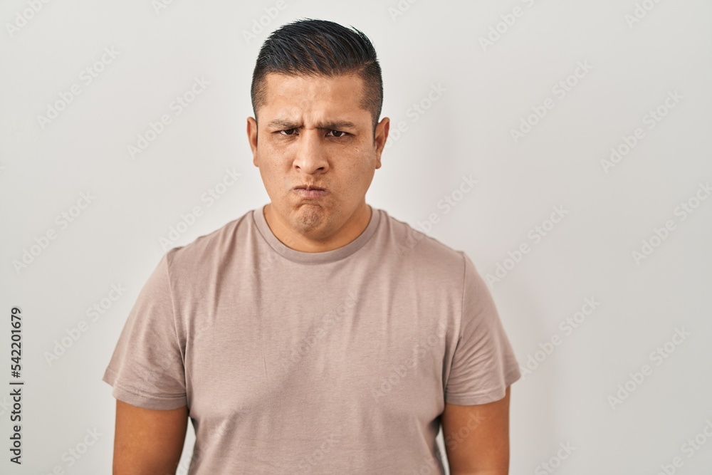 Hispanic young man standing over white background skeptic and nervous, frowning upset because of problem. negative person. Hispanic young man standing over white background skeptic and nervous, frowning upset because of problem. negative person.