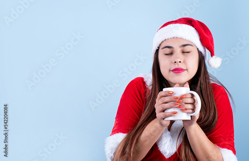 closeup of caucasian happy woman wearing santa clothes holding white mug