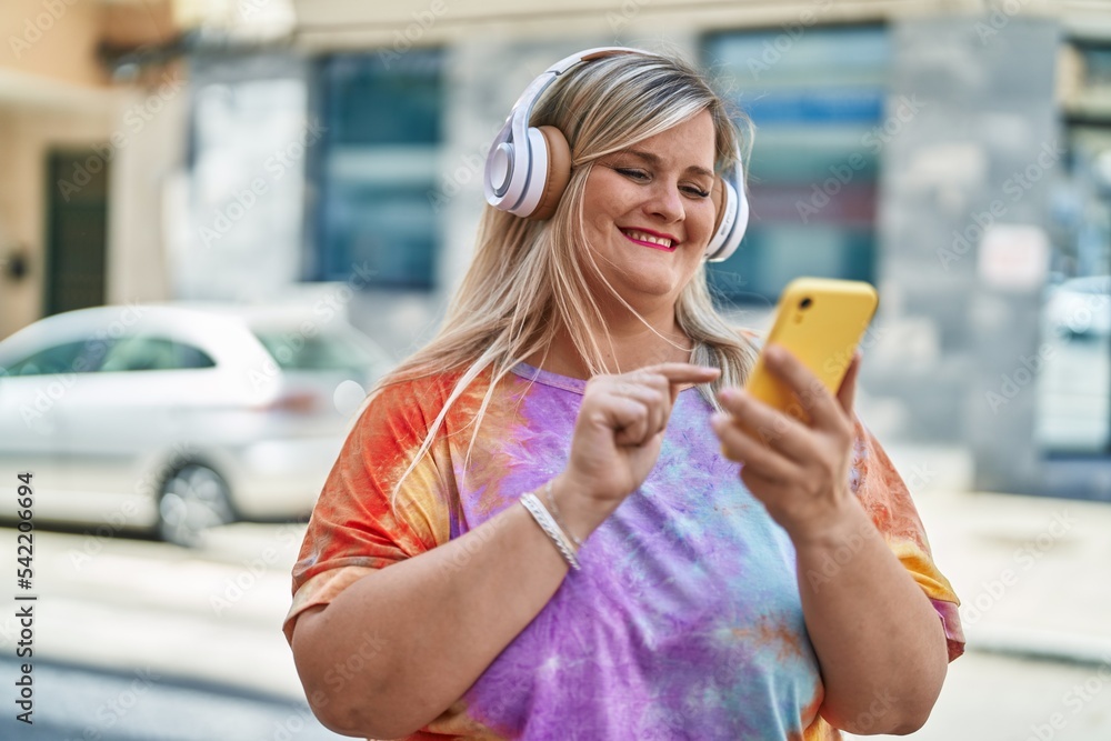 Young woman smiling confident listening to music at street