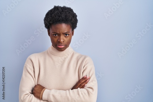 Wallpaper Mural African american woman standing over blue background skeptic and nervous, disapproving expression on face with crossed arms. negative person. Torontodigital.ca