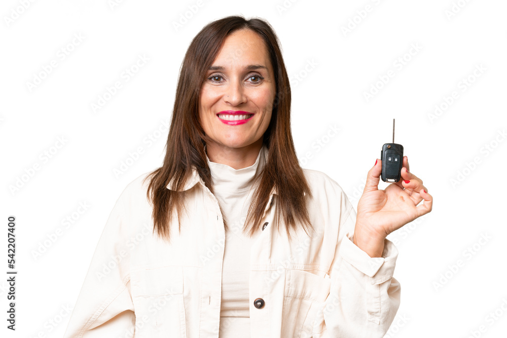 Middle-aged woman holding car keys over isolated background smiling a lot Middle-aged woman holding car keys over isolated background smiling a lot