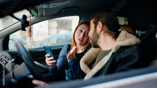Man and woman couple using smartphone driving car at street © Krakenimages.com