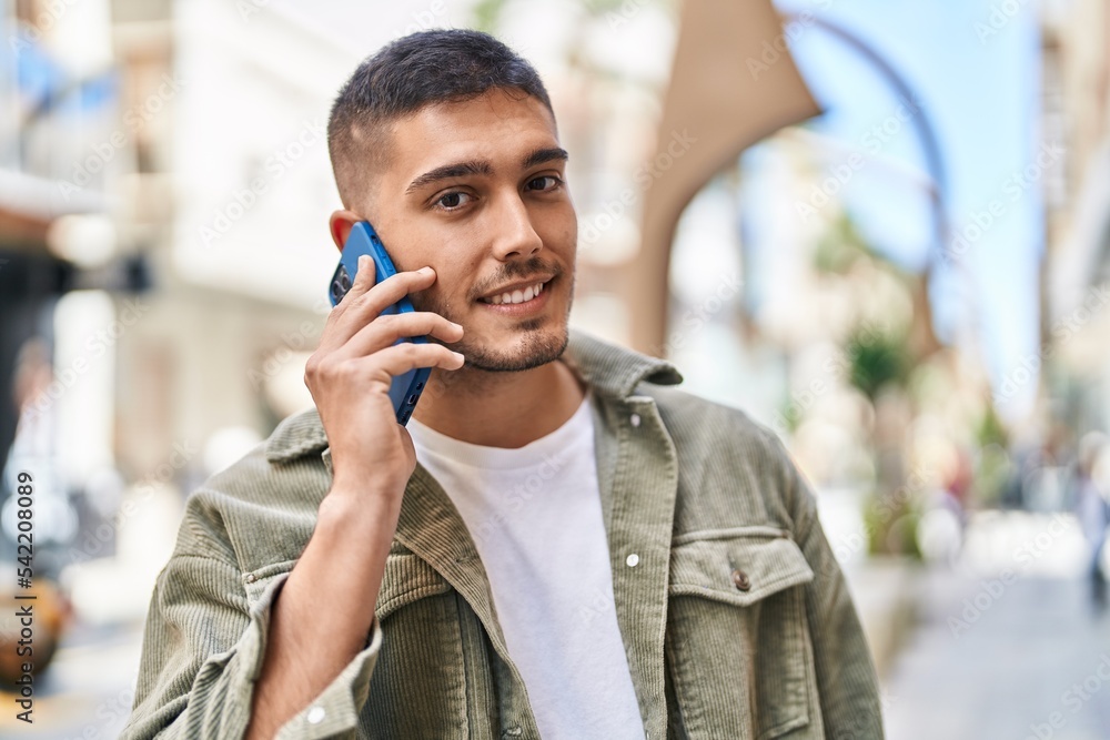 Young hispanic man smiling confident talking on the smartphone at street Young hispanic man smiling confident talking on the smartphone at street