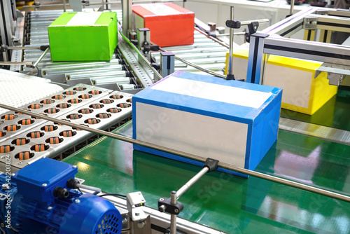 Automated production. Conveyor line with colorful boxes. Production line close up. Concept packaging production line in enterprise. Conveyor tech. Conveyor belt with automated distribution process