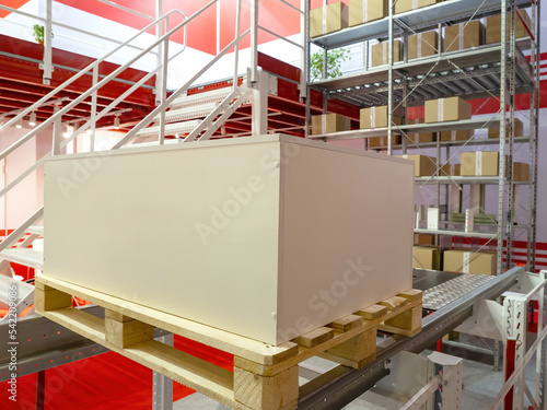 Interior Storage. Pantry Production company. Storage with mezzanine. White cabinet on pallet. Concept of furniture production. Storage with boxes on racks. Company warehouse interior