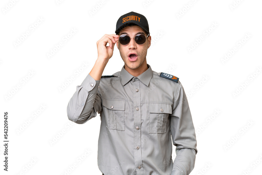 Young security man over isolated background with glasses and surprised Young security man over isolated background with glasses and surprised