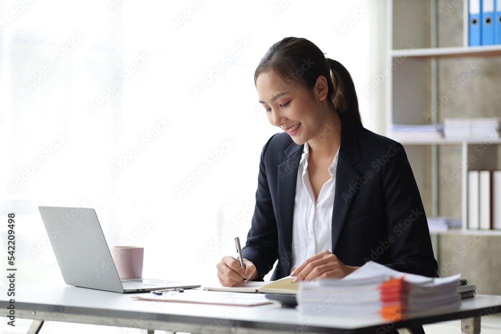 Portrait of charming business woman in office working on laptop and business report papers. Portrait of charming business woman in office working on laptop and business report papers.