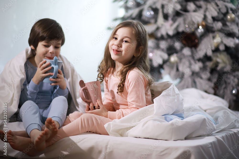 A family with children having fun on the bed under the covers during the Christmas holidays. A family with children having fun on the bed under the covers during the Christmas holidays.