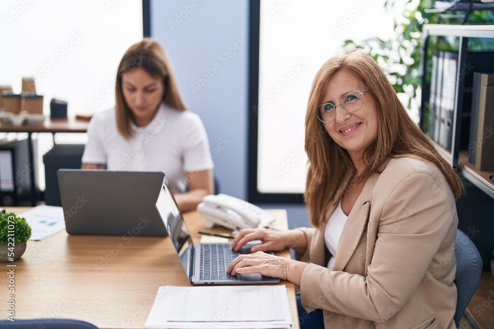 Mother and daughter business workers using laptop working at office Mother and daughter business workers using laptop working at office