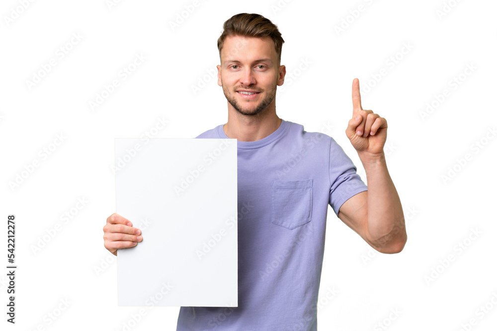 Young blonde caucasian man over isolated background holding an empty placard and pointing up Young blonde caucasian man over isolated background holding an empty placard and pointing up