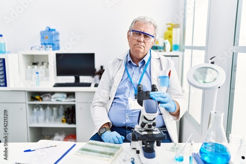 Senior caucasian man working at scientist laboratory looking sleepy and tired  exhausted for fatigue and hangover  lazy eyes in the morning.