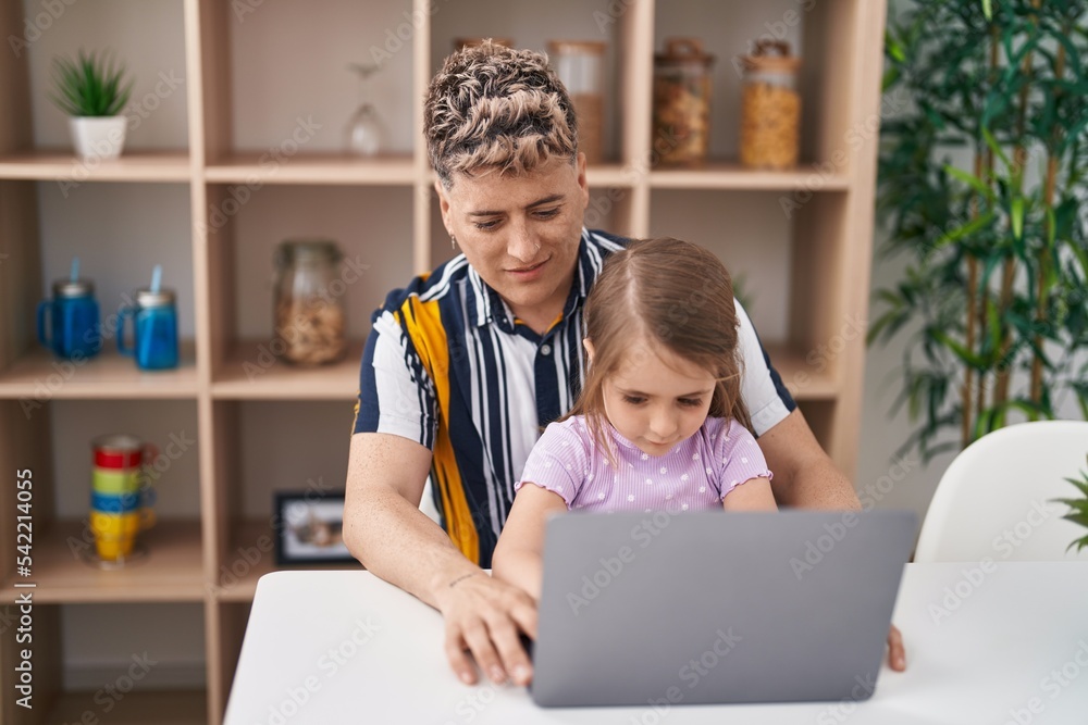 Father and daughter father and daughter using laptop sitting on table at home Father and daughter father and daughter using laptop sitting on table at home