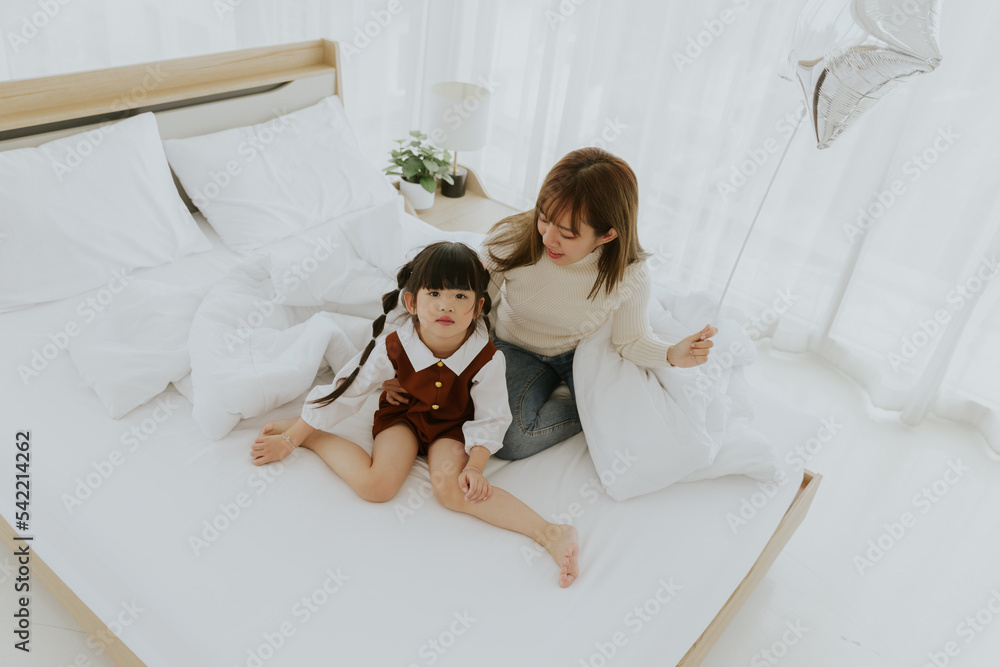 Φωτογραφία Young asian mother and 4years old kid daughter lying smiling and playing balloon