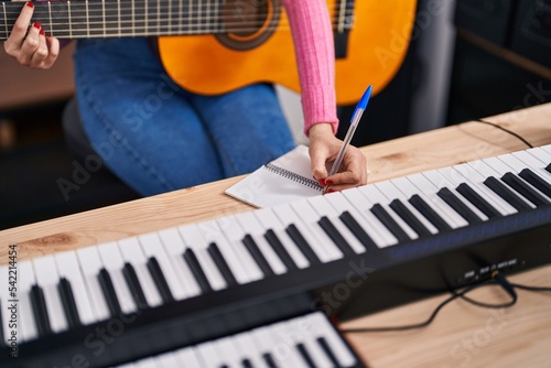 Canvas Print Young caucasian woman musician composing song playing classical guitar at music