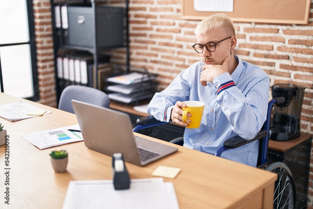 Young caucasian man business worker drinking coffee sitting on wheelchair at office Young caucasian man business worker drinking coffee sitting on wheelchair at office