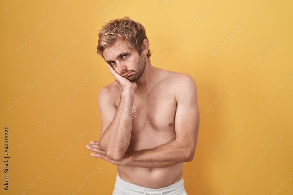 Caucasian man standing shirtless wearing sun screen thinking looking tired and bored with depression problems with crossed arms.