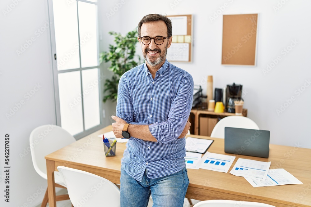 Middle age hispanic man with beard wearing business clothes at the office happy face smiling with crossed arms looking at the camera. positive person. Middle age hispanic man with beard wearing business clothes at the office happy face smiling with crossed arms looking at the camera. positive person.