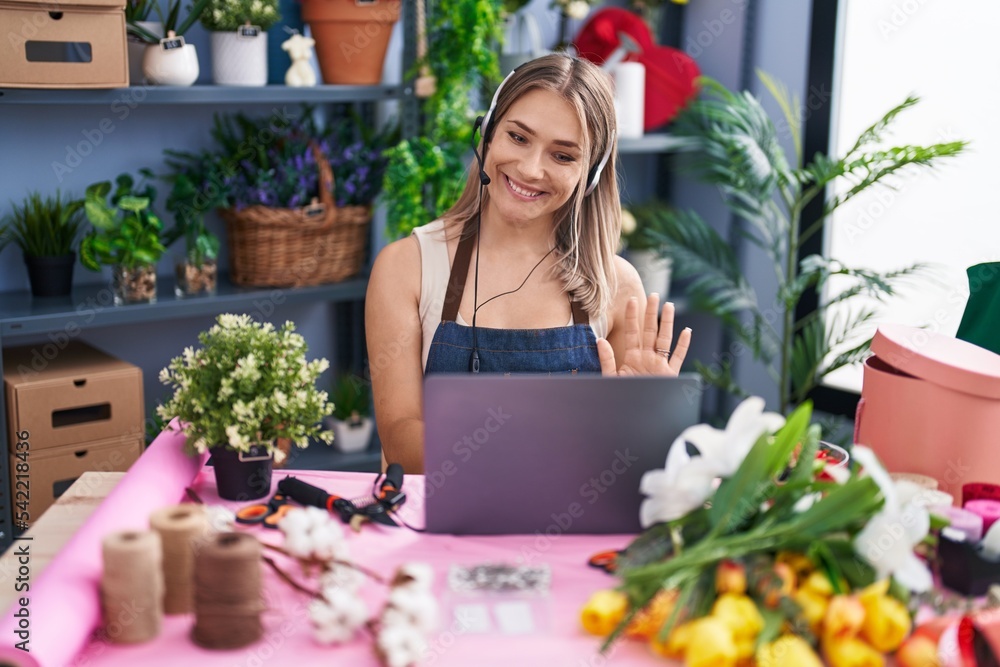 Blonde caucasian woman working at florist shop online looking positive and happy standing and smiling with a confident smile showing teeth