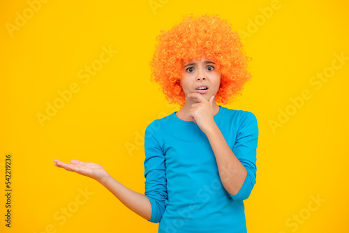 Funny kid with curly hair wig. Cute little girl with fancy hair. Child wearing bright redhead clown hair wig. Excited teenager, glad amazed and overjoyed emotions.