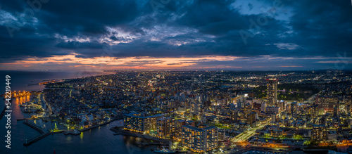 Fototapeta Naklejka Na Ścianę i Meble -  Panoramic aerial view of waterfront city at night with sunset afterglow