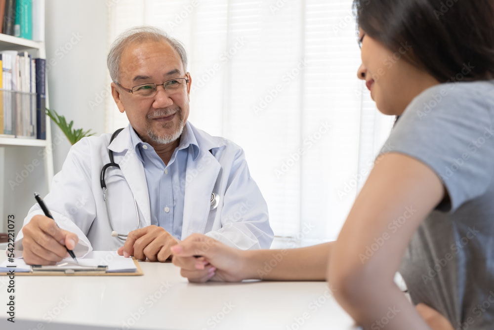 Close up doctor talking with the patient at a desk in the clinic