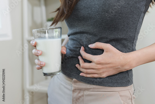 lactose intolerance concept. Woman pushing glass of milk deny to drink.