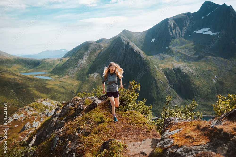 Healthy lifestyle woman trail running in mountains outdoor travel adventure active trip female athlete training motivation concept Norway nature Senja island
