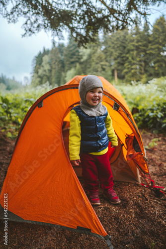 Child hiking with camping tent travel family vacation outdoor in forest adventure lifestyle happy smiling emotional 2 years old kid