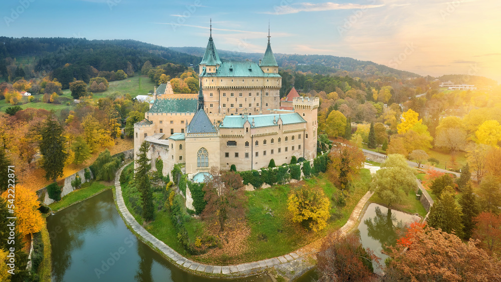 Bojnice castle. Panoramic aerial view of a neo-gothic romantic fairy-tale castle in a colourful autumn garden. Fortification, towers and water moat. UNESCO  travel concept of the castle and chateau.