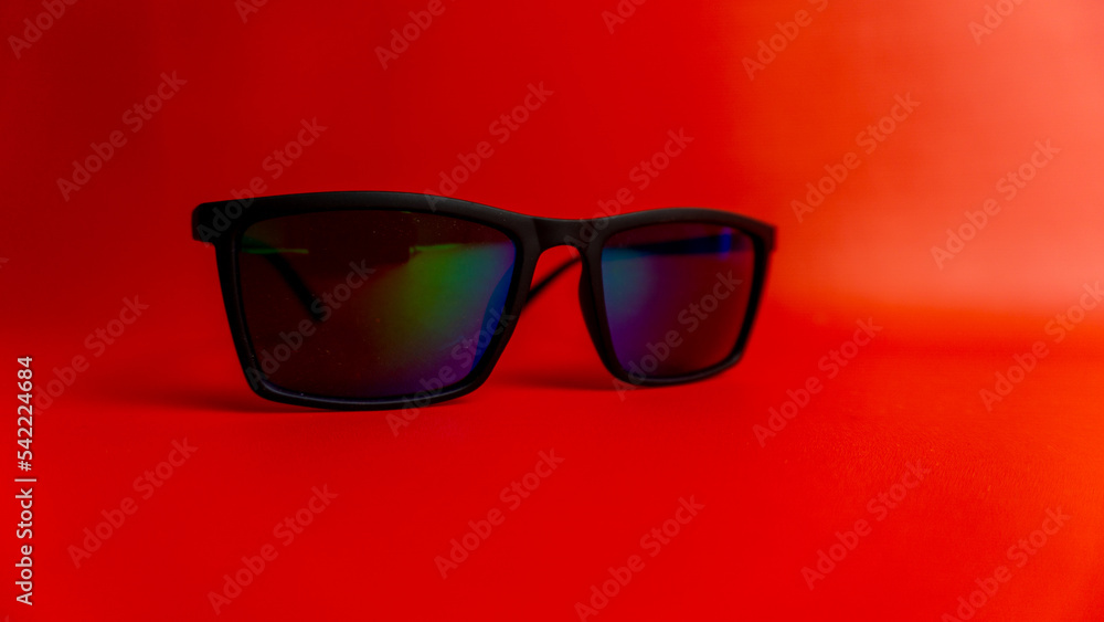 Black sunglasses on red background Black sunglasses on red background
