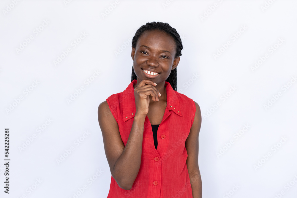 Happy woman touching chin. Female African American model in red vest listening attentively and smiling. Portrait, studio shot, friendliness concept.