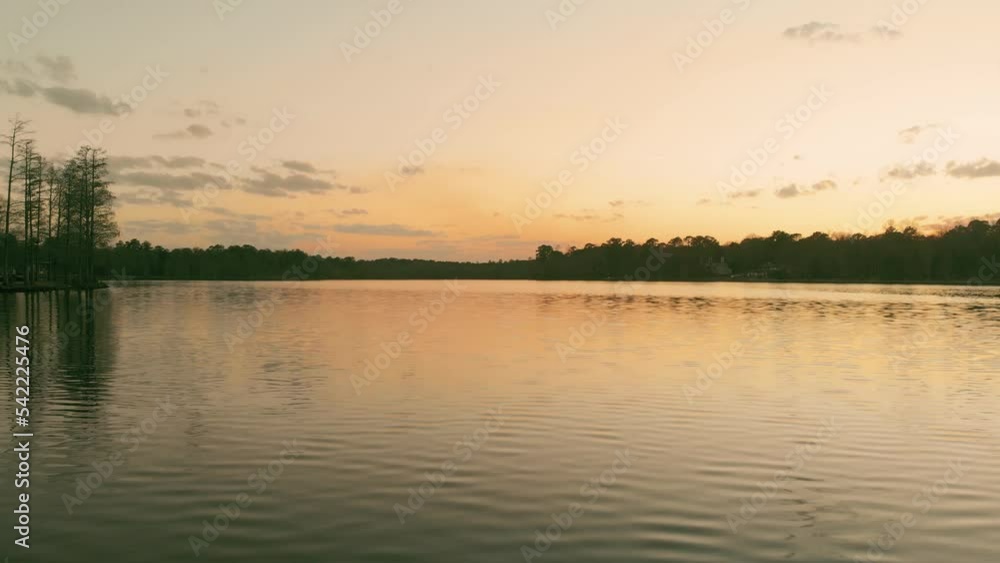 Beautiful shot of a clear large lake under a golden sunset sky Beautiful shot of a clear large lake under a golden sunset sky