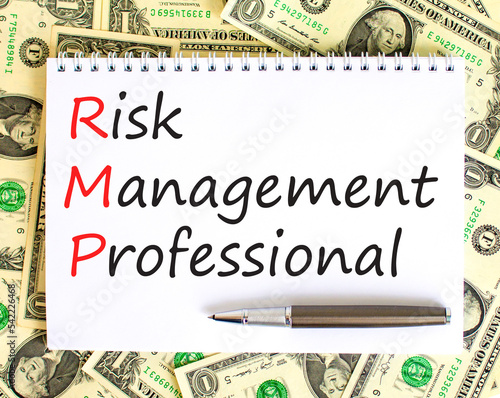 RMP risk management professional symbol. Concept words RMP risk management professional on white note on a background from dollar bills. Business RMP risk management professional concept. Copy space. photo