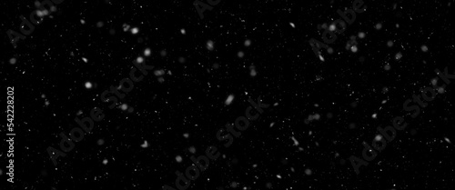 Falling snow isolated on black background. Falling snow at night. Bokeh lights on black background, flying snowflakes in the air. Winter weather. Overlay texture. 