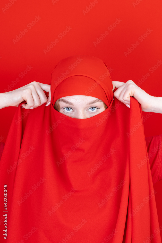 Young asian muslim woman with beautiful eyes covering her face with scarf isolated on white background