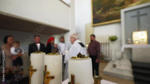 Blurry: Baptism process in a catholic church with priest and newborn's family photo