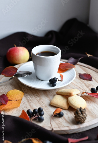 Autumn still life with a cup of coffee, cookies and burgundy leaves