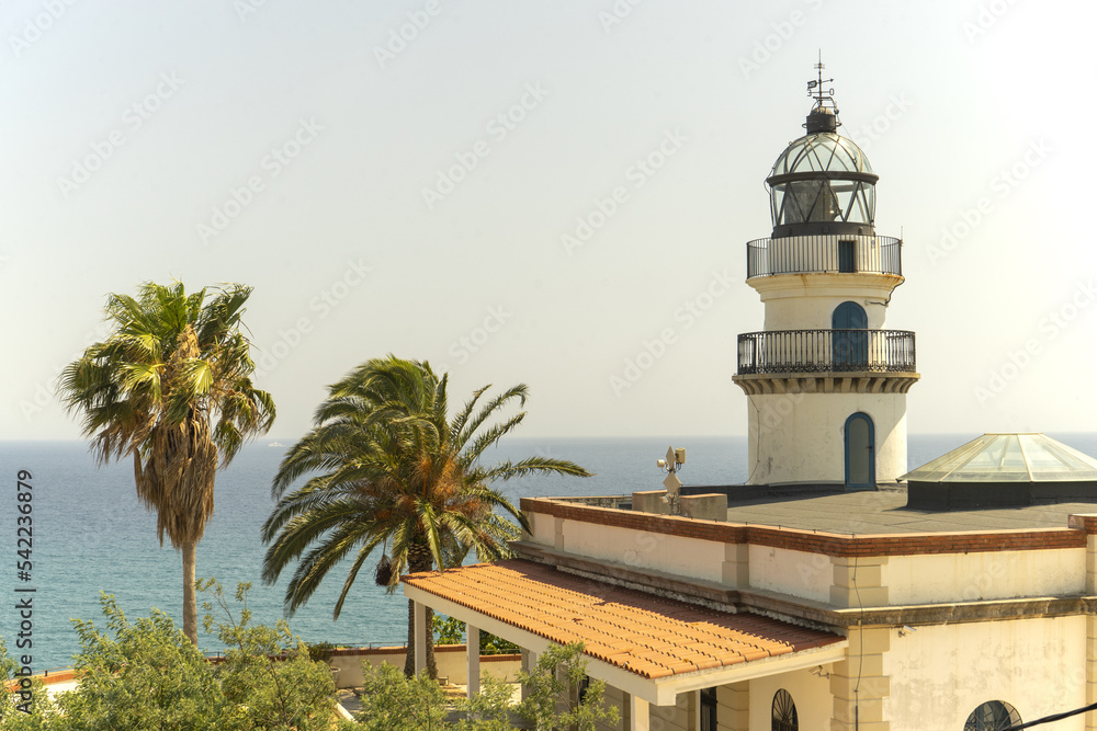 Lighthouse on the seashore. Palms. Spain. Summer