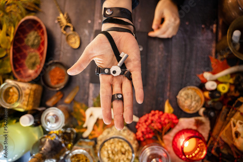Hand holding an old key on the background of the occult altar. Preparing the Road Opener elixir, traditionall used in Hoodoo and Voodoo. Wicca, a Pagan magical potion commonly used to start new things