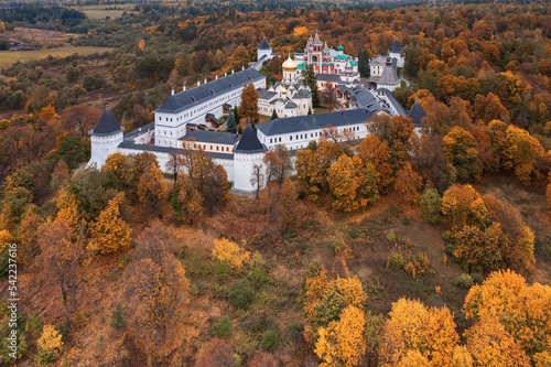 Russian Orthodox monastery behind whitewashed walls surrounded by autumn trees, Zvenigorod, Russia