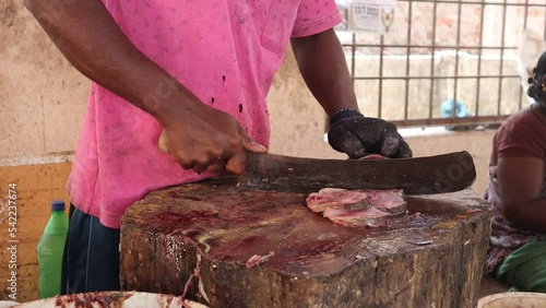 Fish cutting skill at the Indian fish market. An unidentified man's hand slicing a fish at a fish market. photo