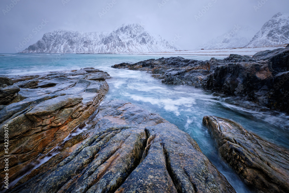 Waves and rocks on coast of Norwegian sea in fjord. Skagsanden beach, Flakstad, Lofoten islands, Norway. Long exposure motion blur